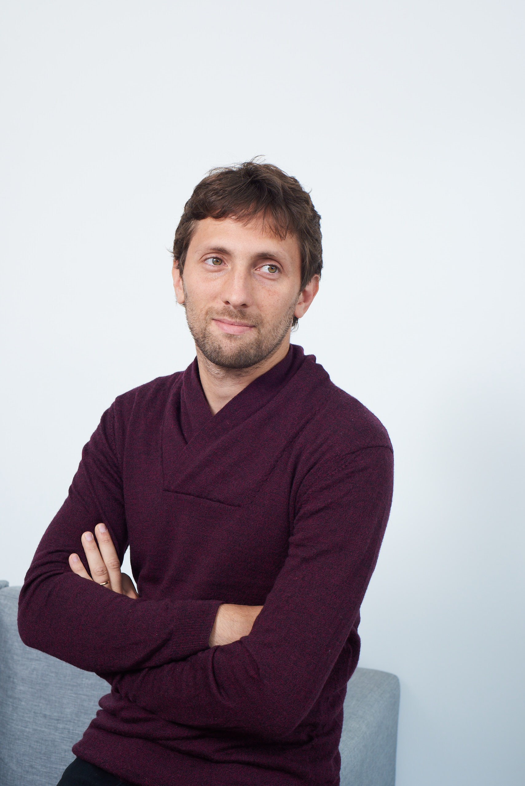 Gaston Krasny, co-founder of SeSocio, in a burgundy sweater with arms crossed — corporate headshot
